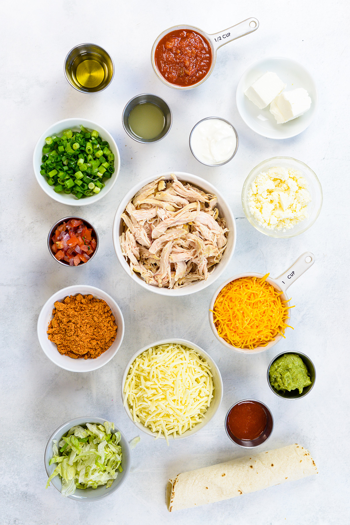Chicken flauta ingredients spread out on a white countertop.
