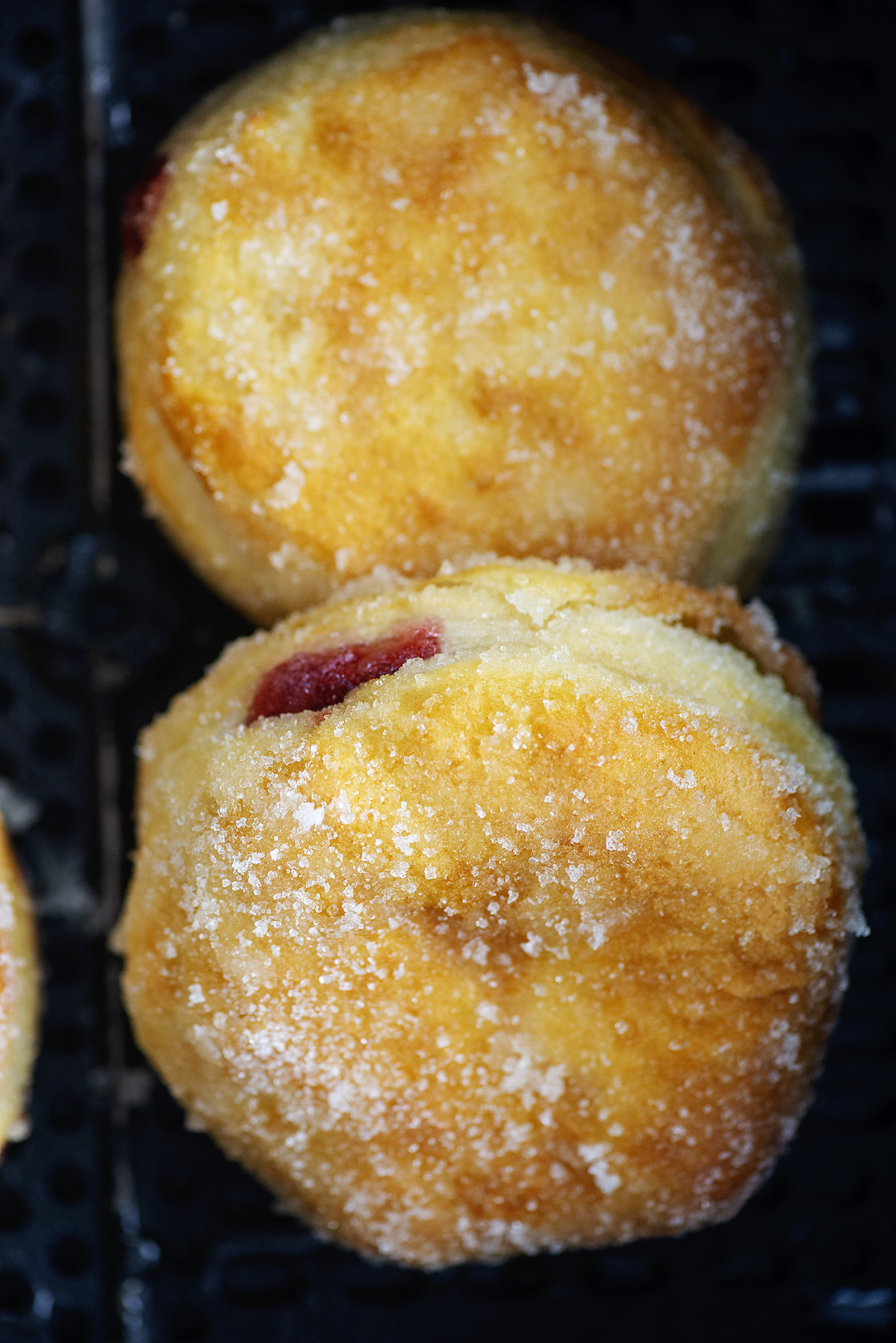 Two cooked jelly donuts in an air freyr basket.