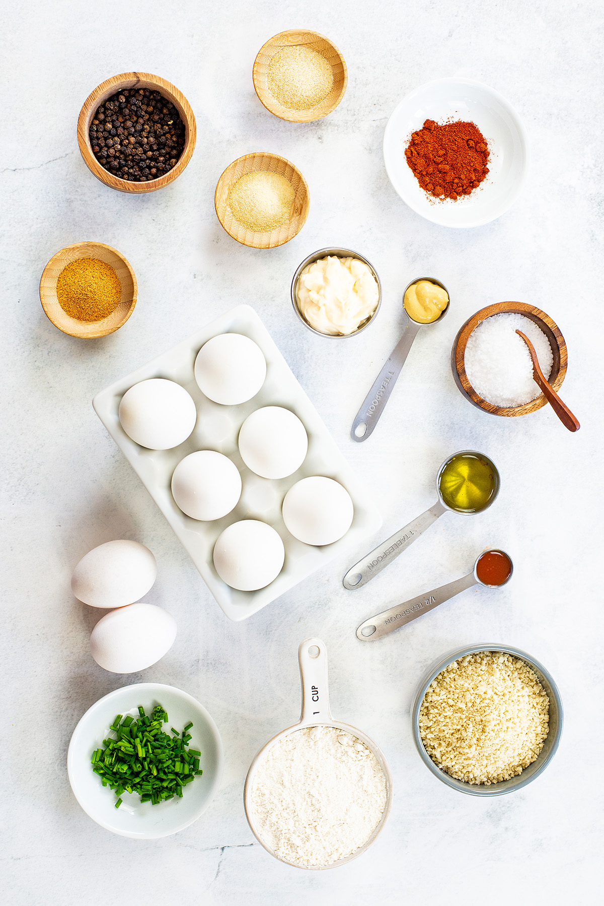 Fried deviled egg ingredients spread out on a white countertop.
