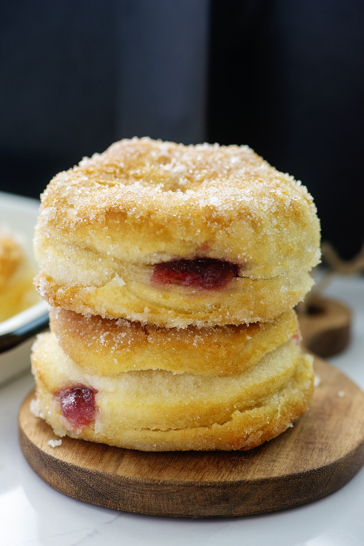 Two sugar coated jelly donuts stacked up.