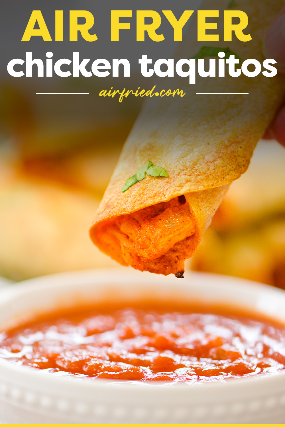 A chicken taquito being dipped into salsa.