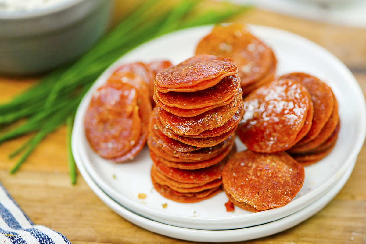 Close up of pepperoni on a white plate.