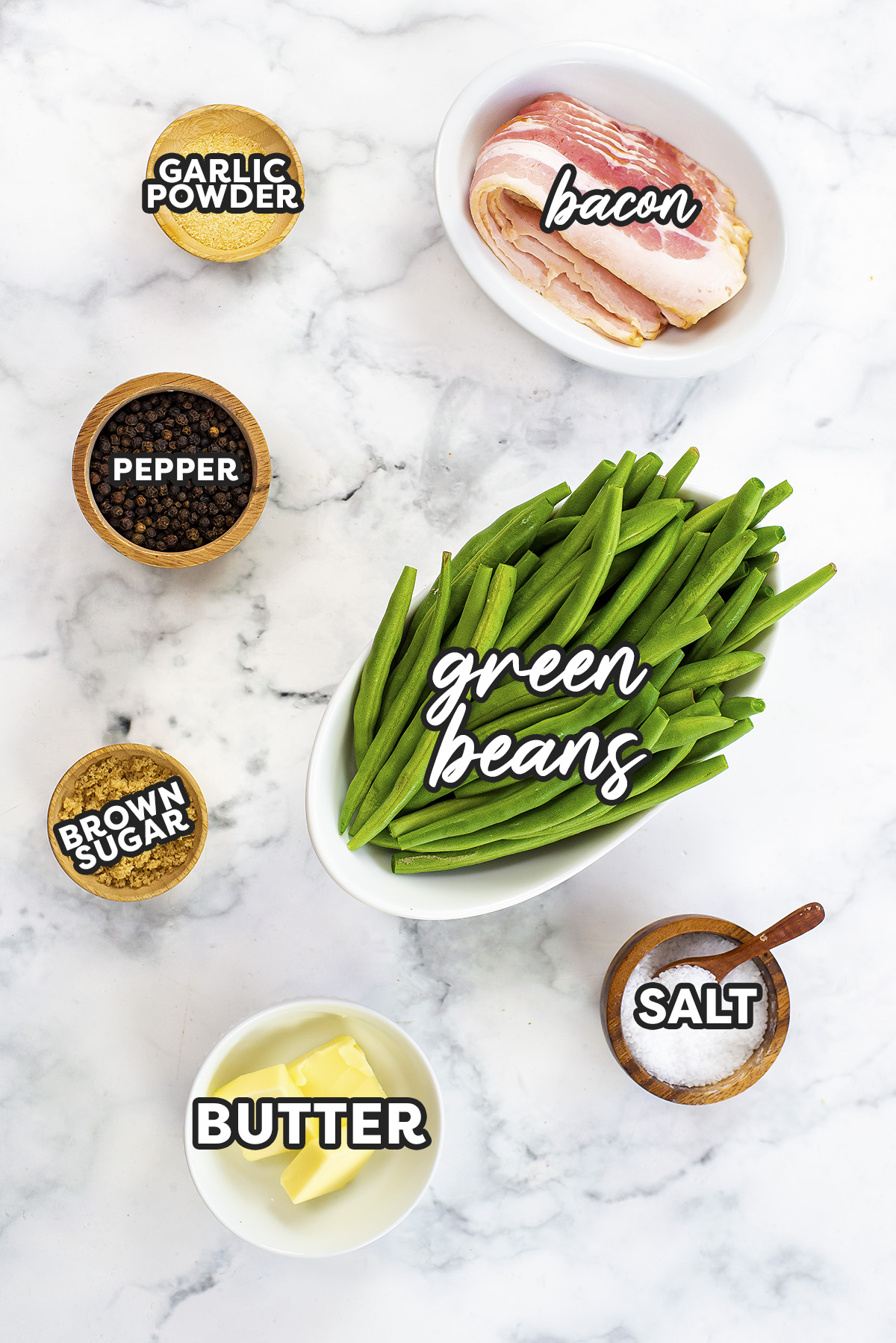 Ingredients needed for bacon wrapped green beans on a white countertop.