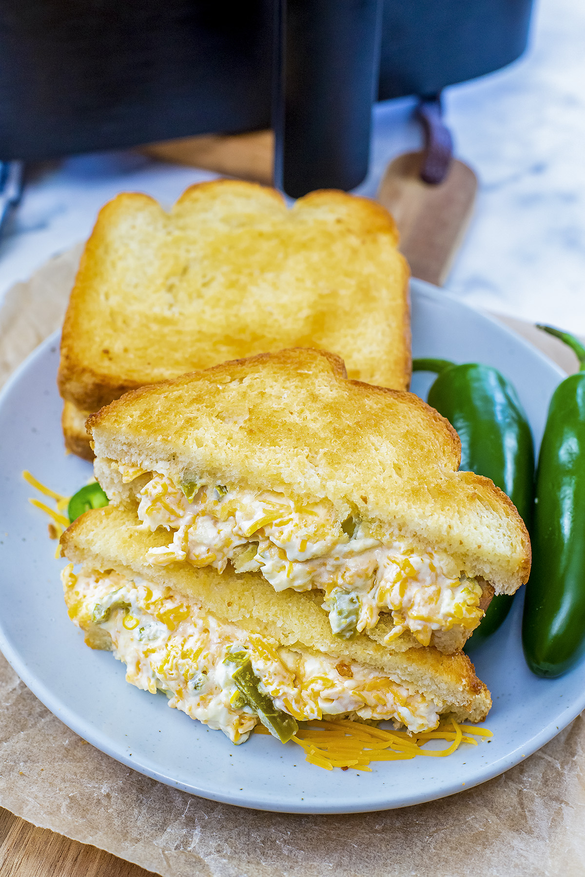 Two jalapeno popper grilled cheese sandwiches on a plate.