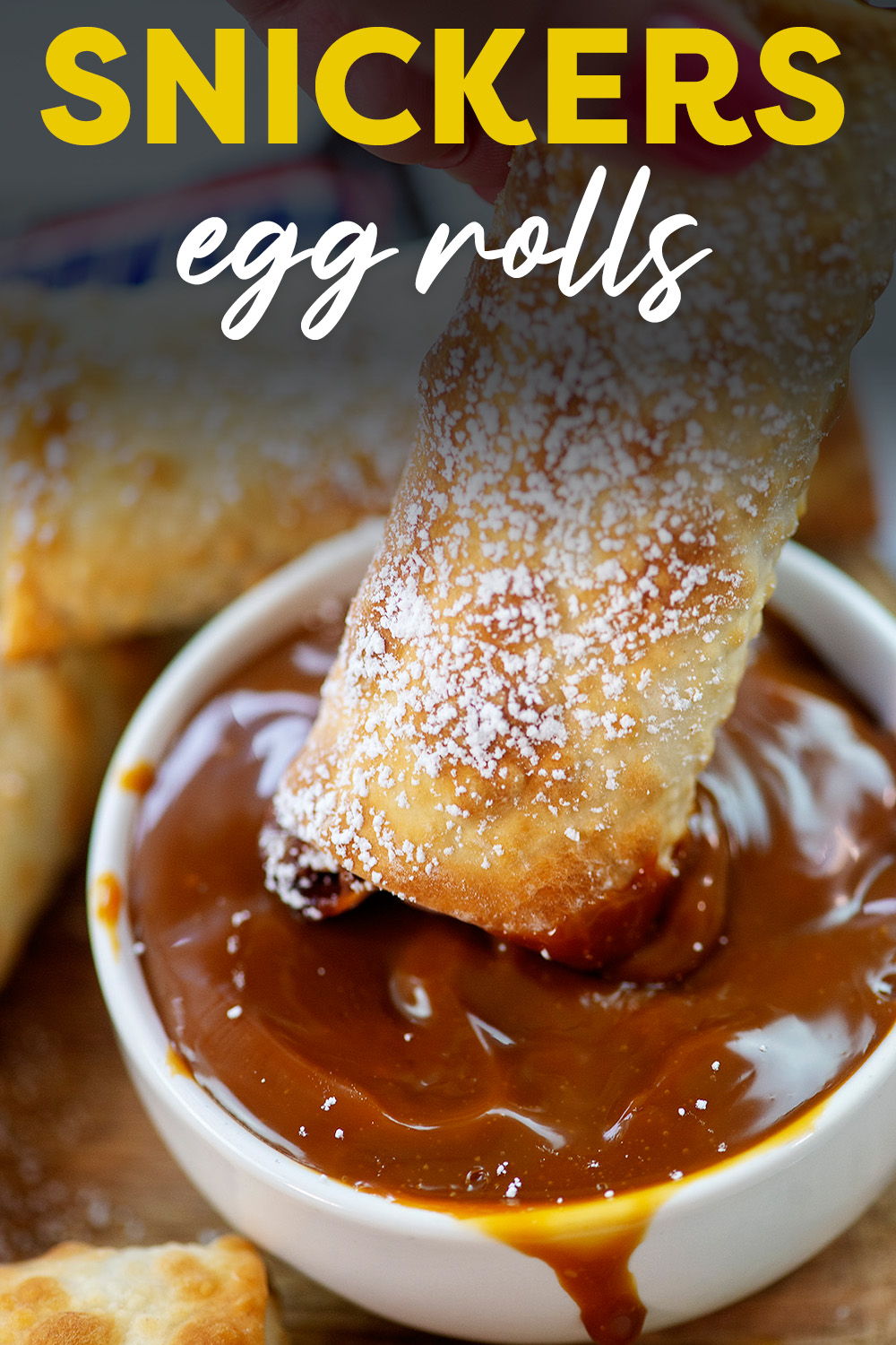 An egg roll being dipped into caramel sauce.