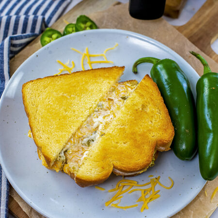 Jalapeno popper grilled cheese on a white plate.