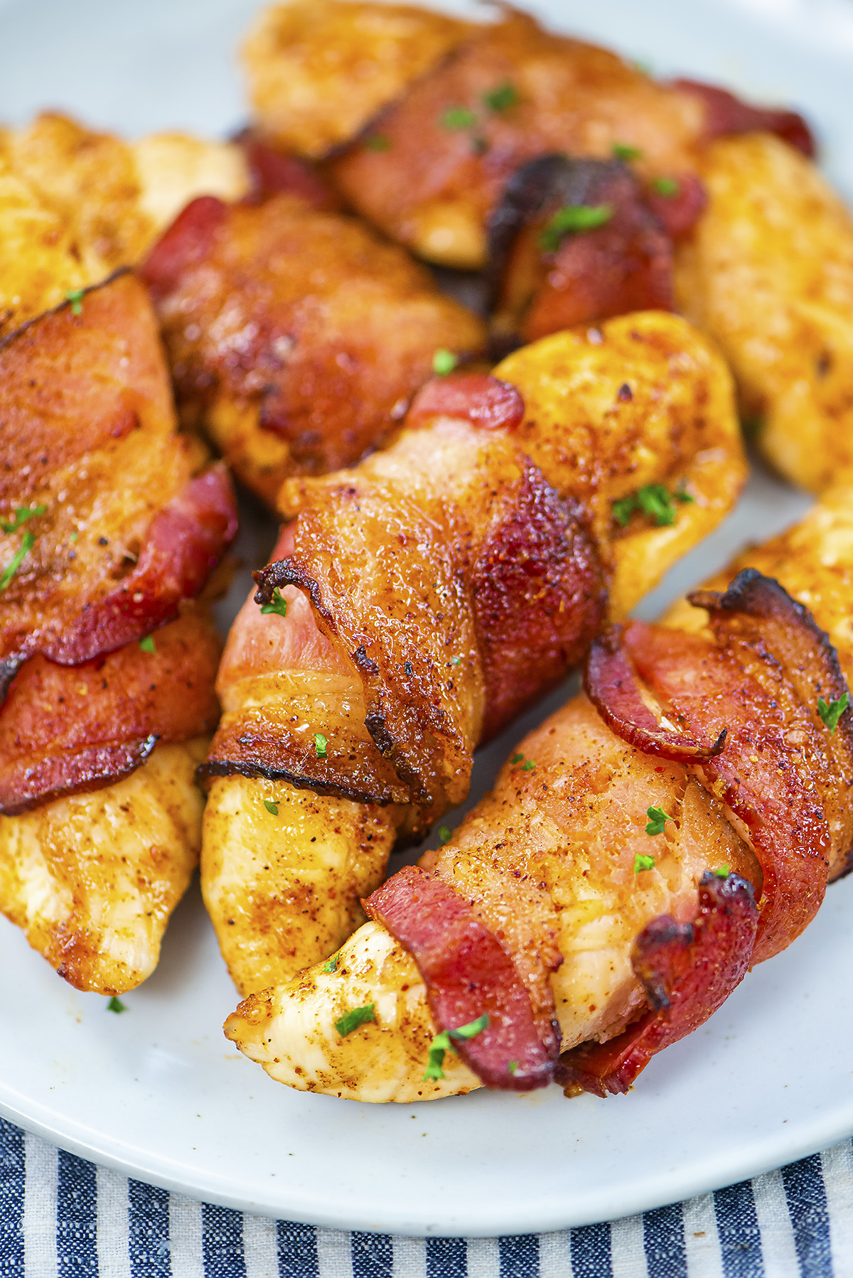 Close up of a bacon wrapped chicken tender.