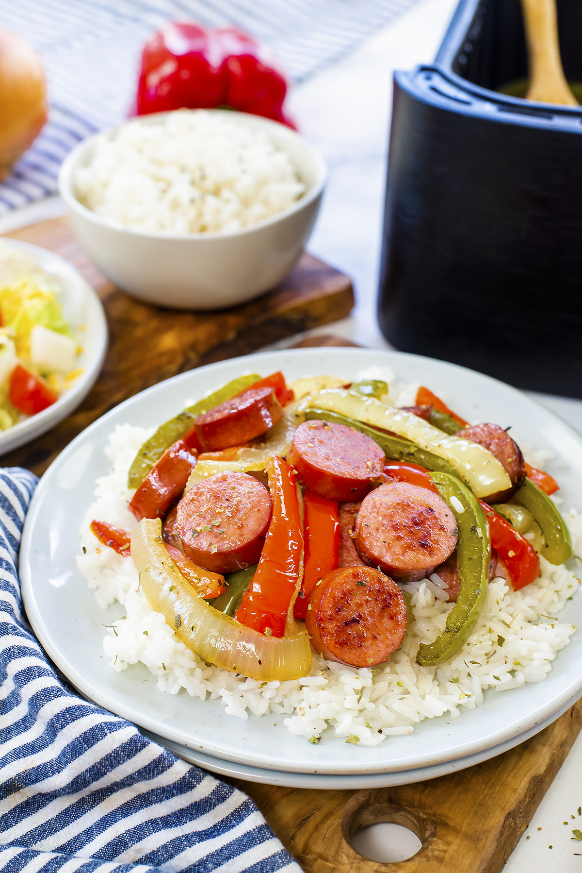 Close up of sausage, peppers, and onions on rice.