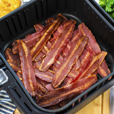 An air fryer basket full of turkey bacon.