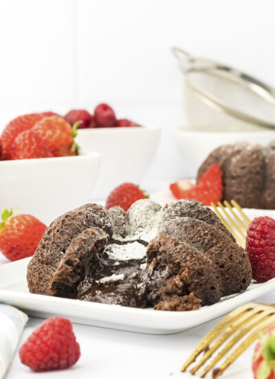 Close up of a lava cake in front of strawberries.