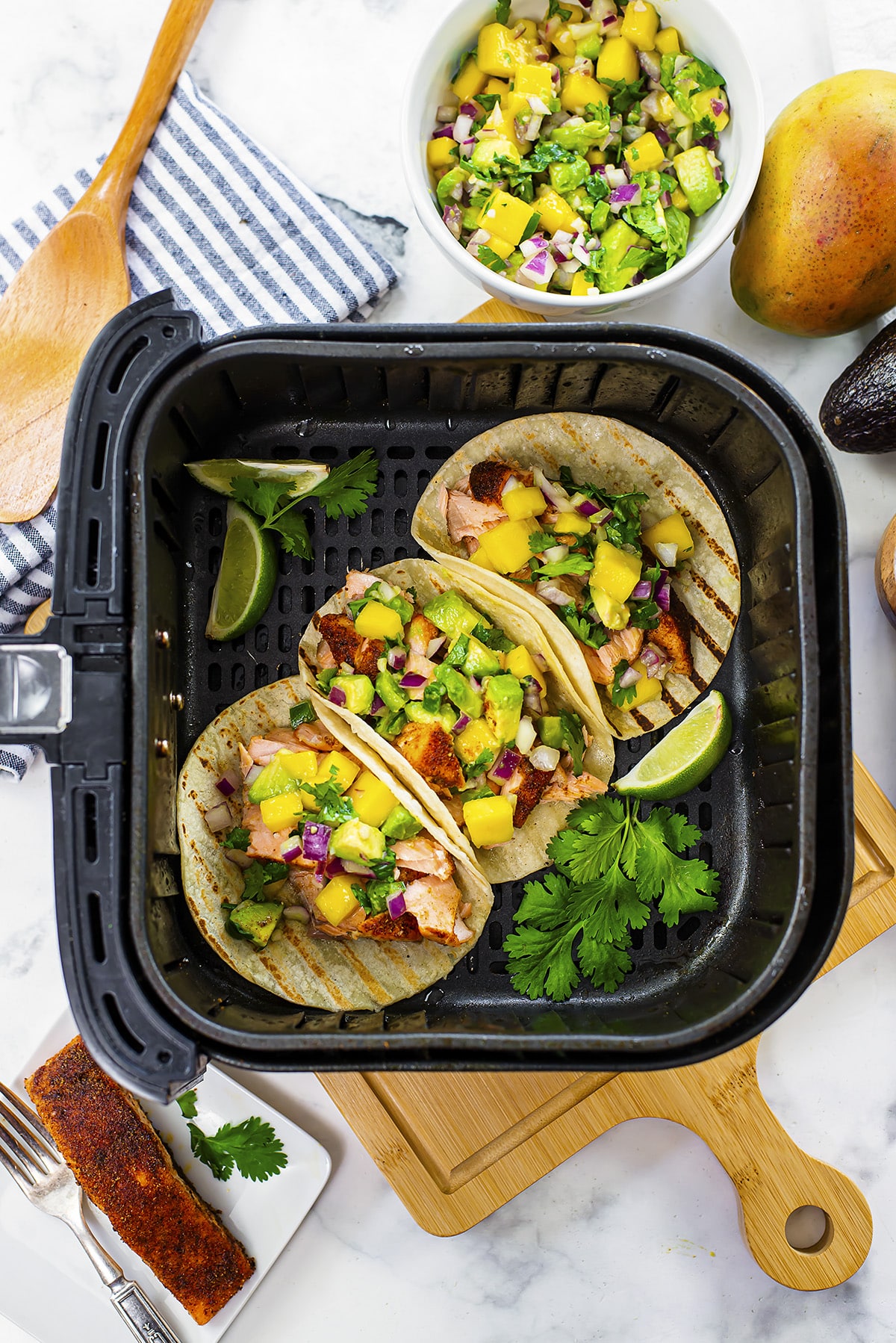 Overhead view of a few salmon tacos in an air fryer.