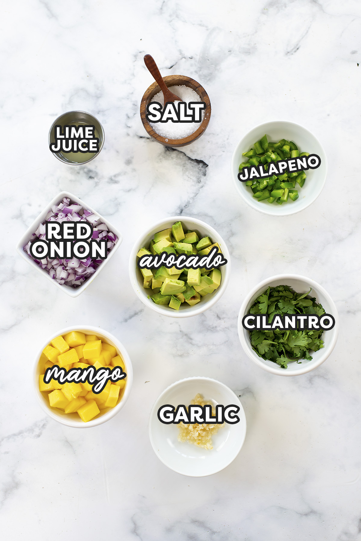 Ingredients for mango avocado salsa on a white countertop.