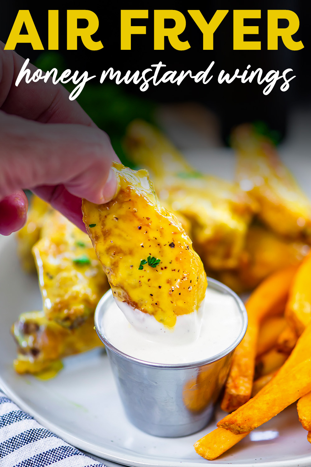 Honey mustard wing being dipped into ranch dressing.