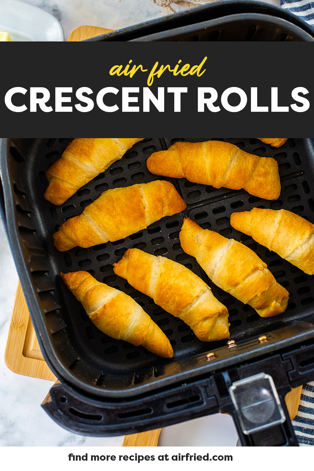 Cooked crescent rolls in an air fryer basket.