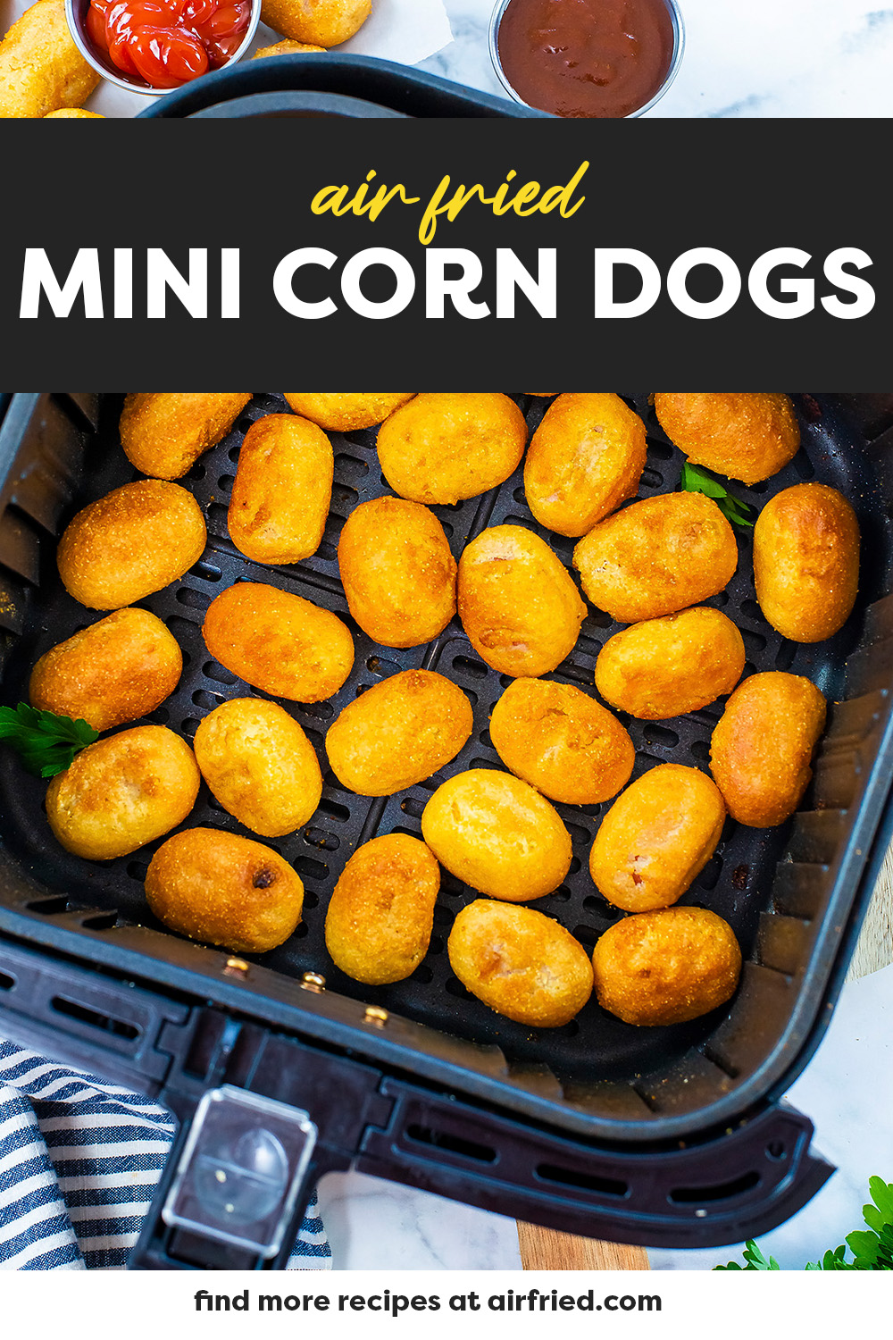 Mini corn dogs in air fryer basket.