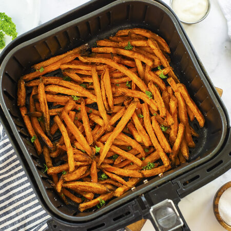 OVerhead view of sweet potato fries in an air fryer basket.