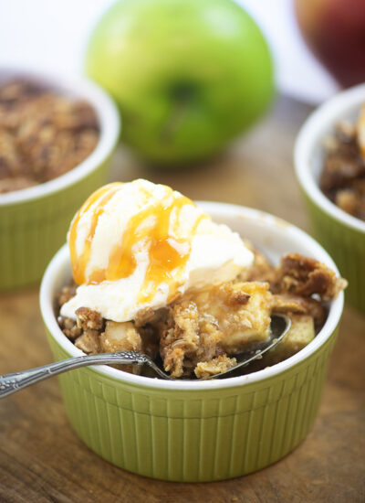Apple crisp and a spoon in a small dish.