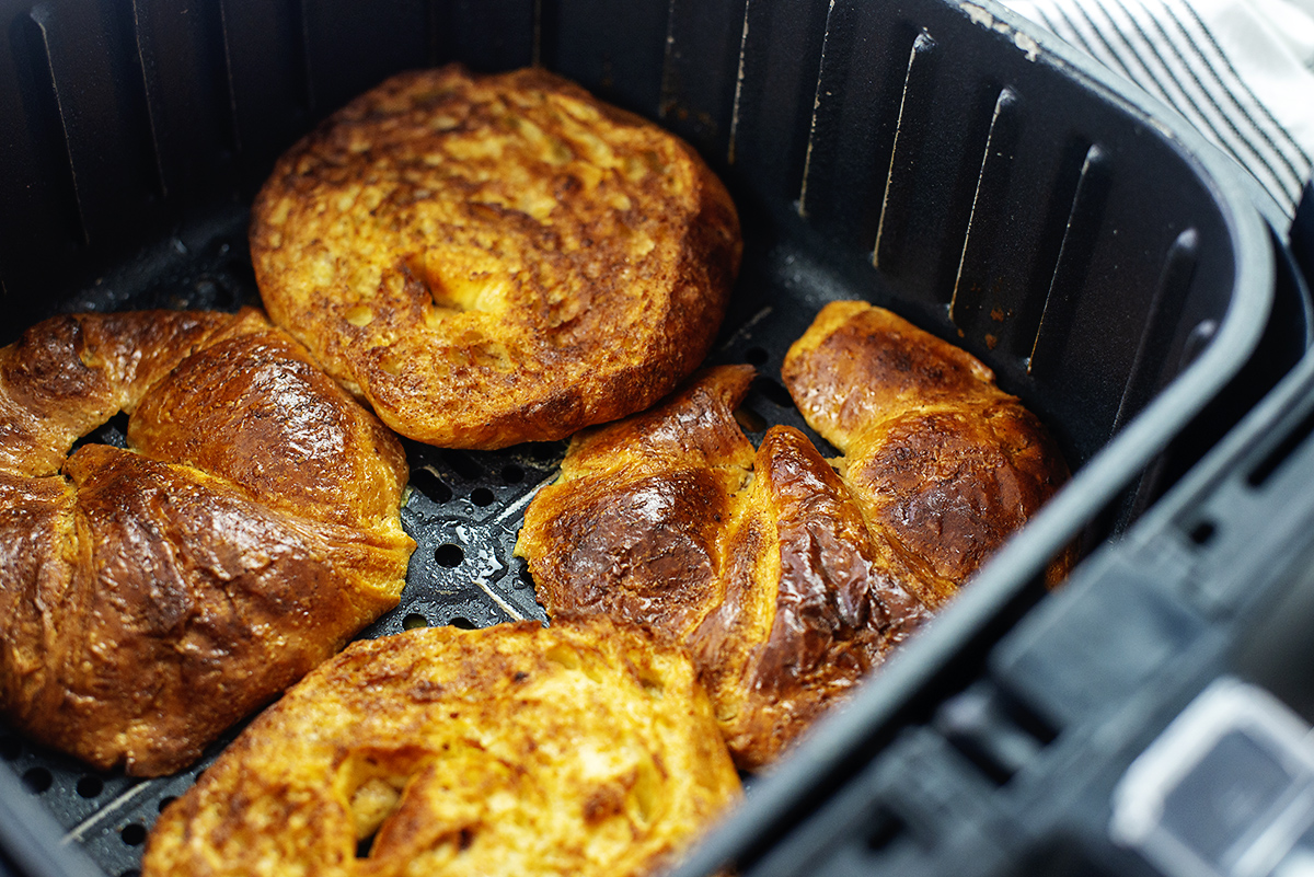 Four pieces of croissant French toast in an air fryer basket.