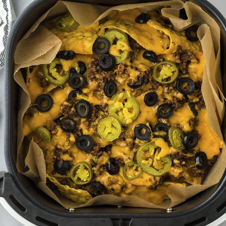 Air fryer nachos in air fryer basket.