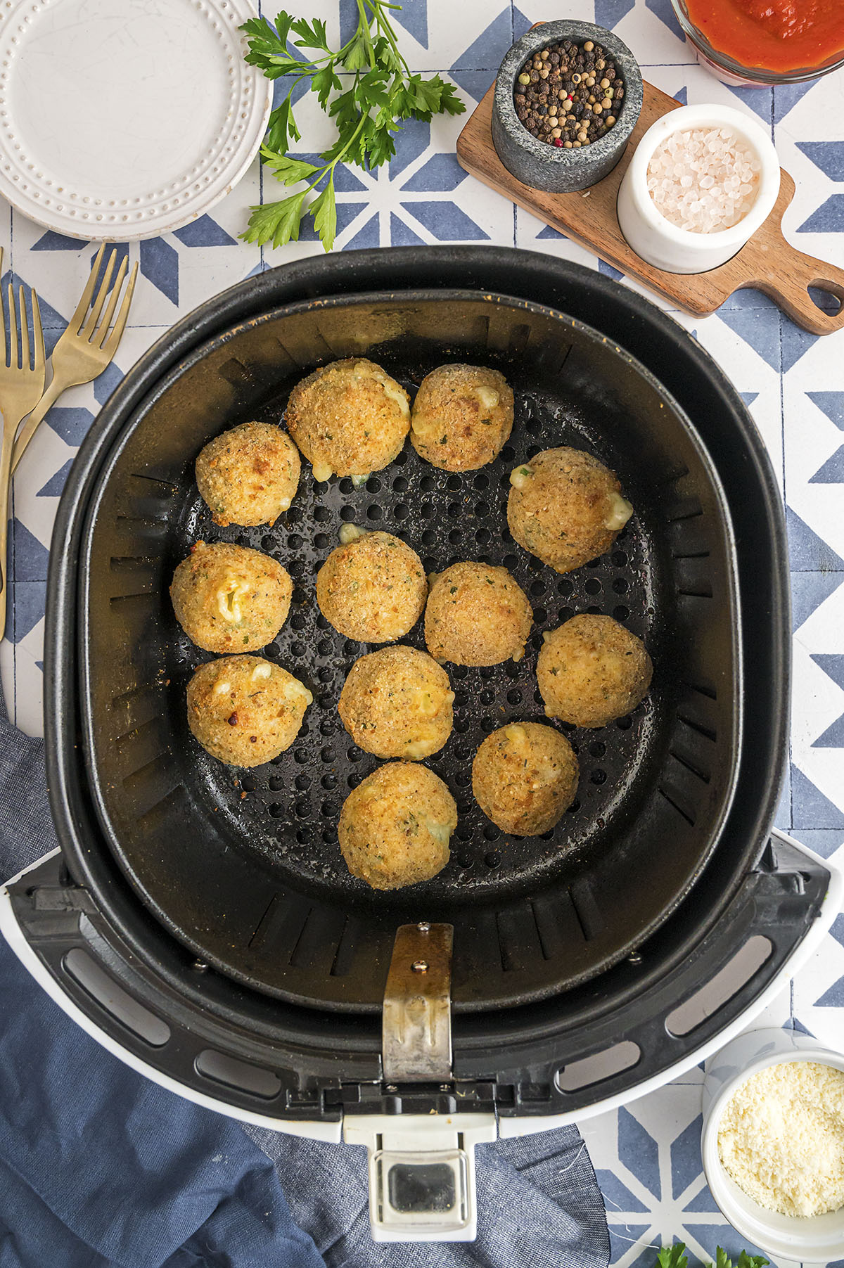 Arancini balls in an air fryer basket.