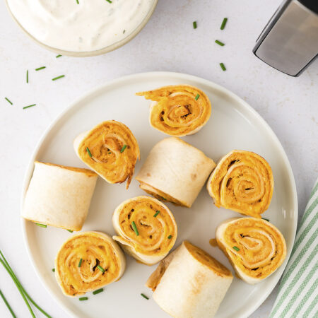A plate with several buffalo chicken pinwheels on it.