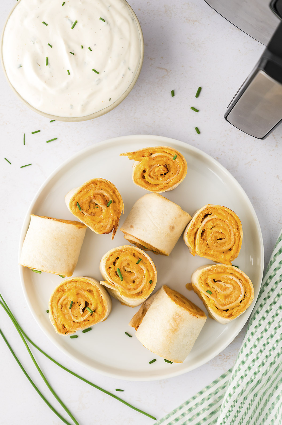 A plate with several buffalo chicken pinwheels on it.