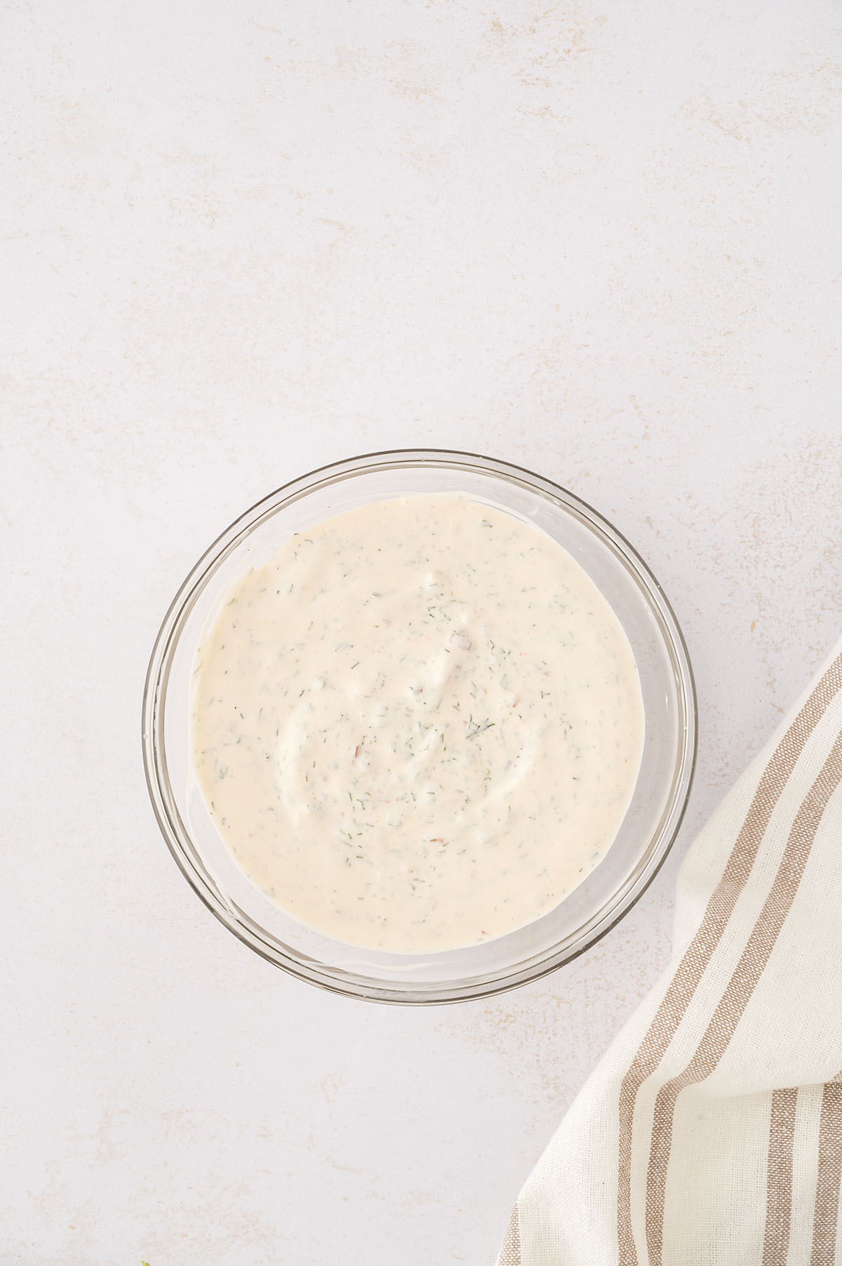 Homemade ranch dressing in a clear glass bowl.