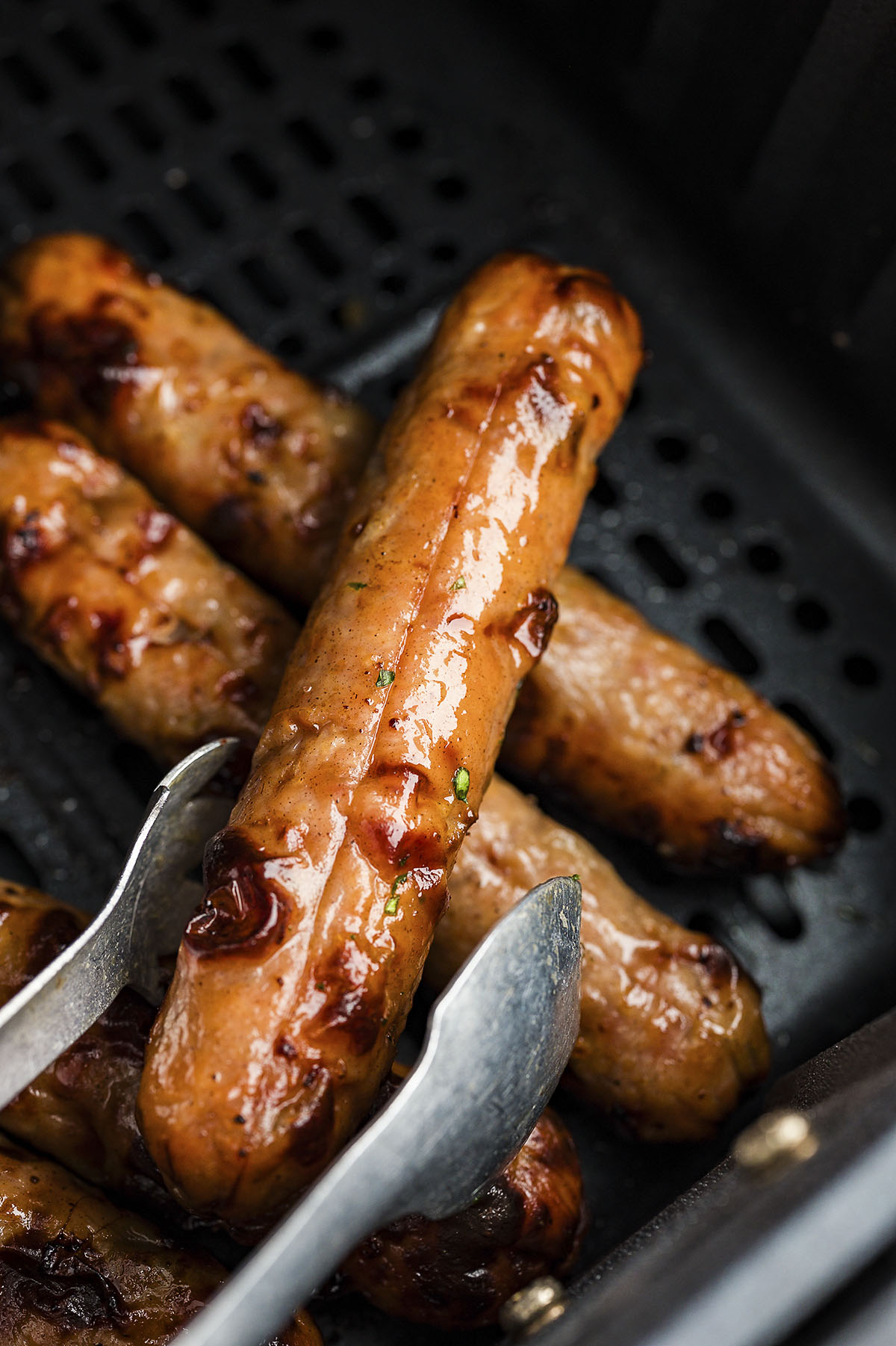 Chicken sausage in air fryer basket.