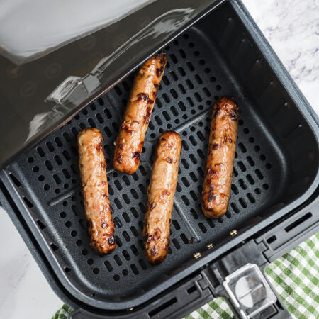 Chicken sausage in air fryer basket.