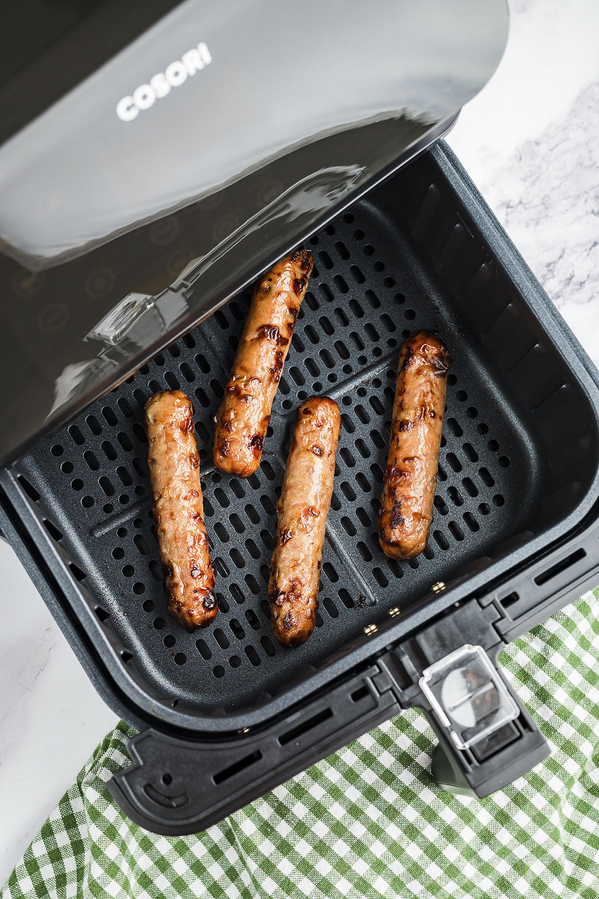 Chicken sausage in air fryer basket.