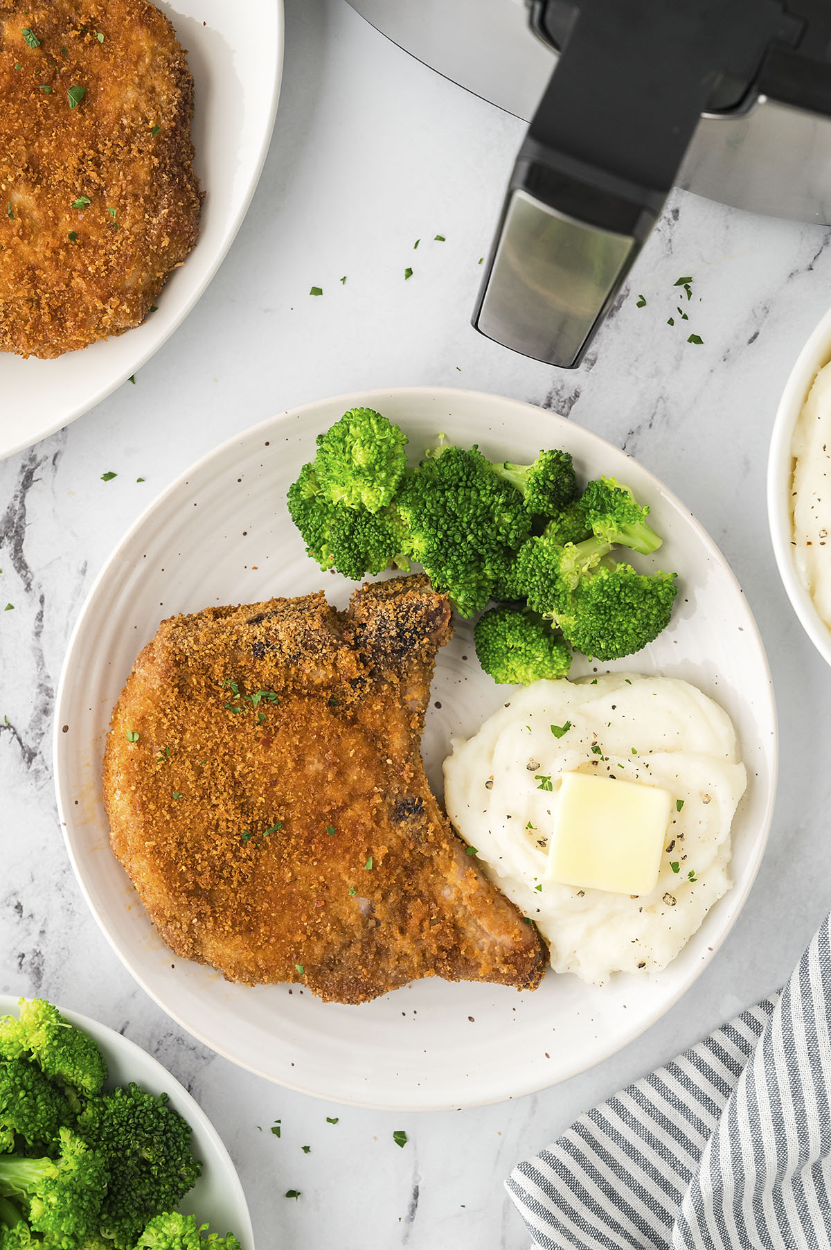 Shake and bake pork chop on plate with mashed potatoes and broccoli.