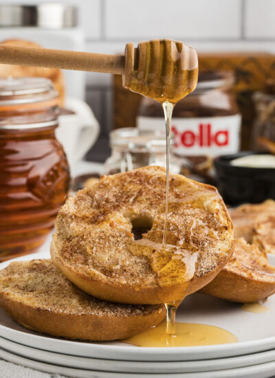 Churro bagel being drizzled with honey.