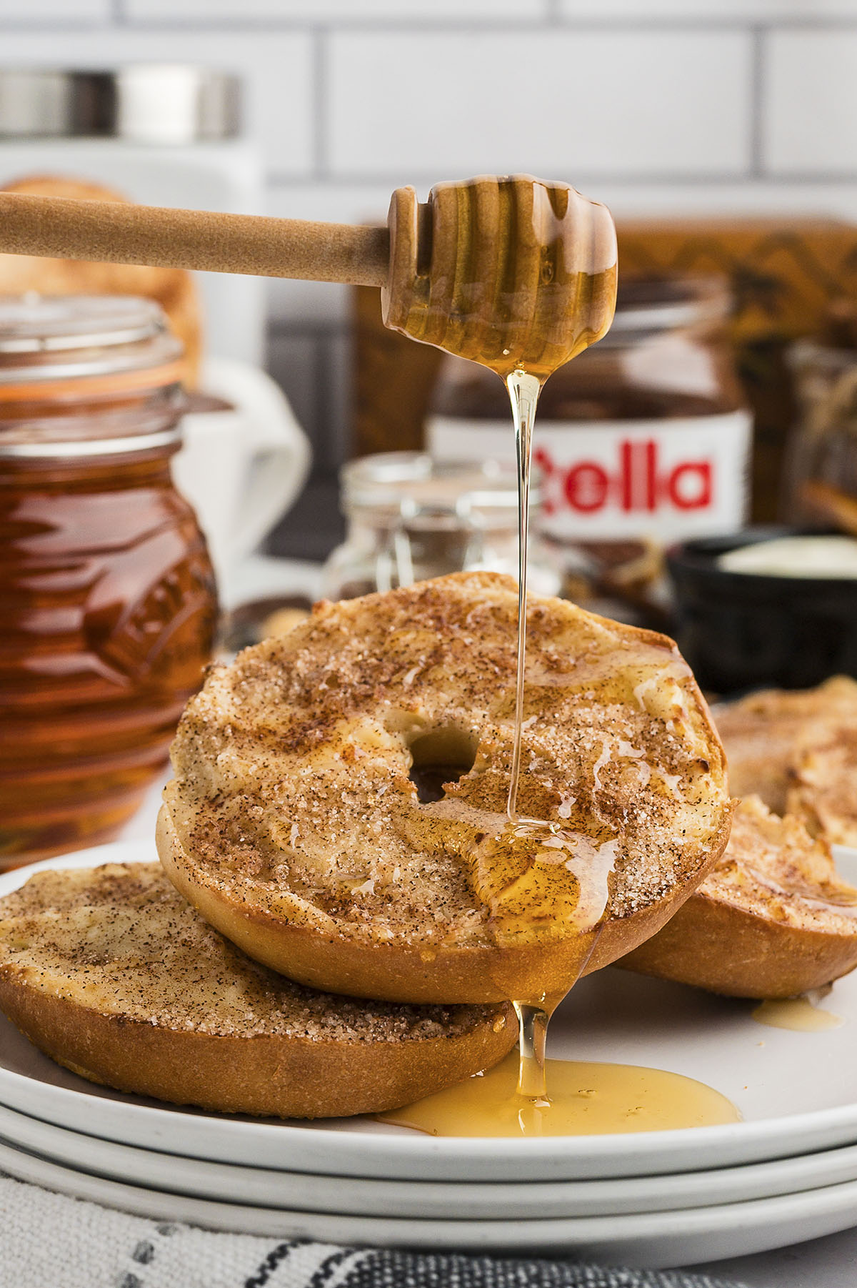 Churro bagel being drizzled with honey.