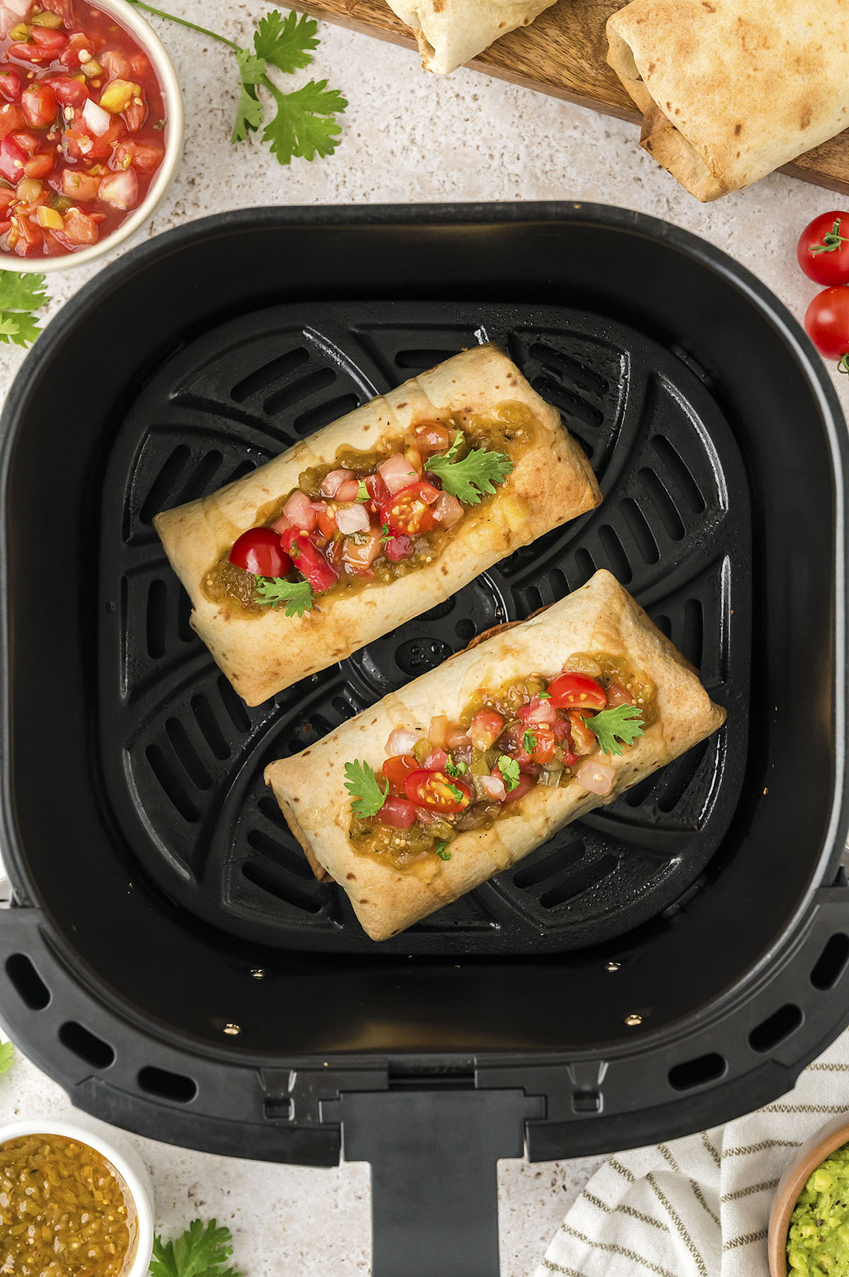 Air fryer chimichangas in basket.