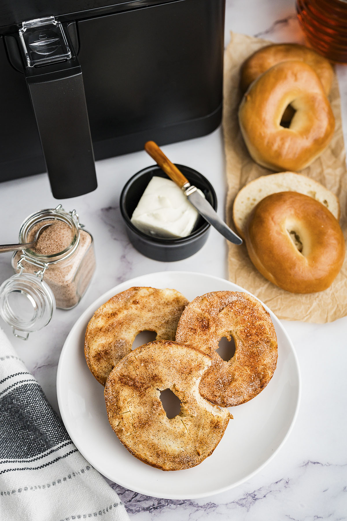 Plate full of churro bagels in front of air fryer.