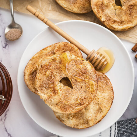 Bagels on white plate wit honey.