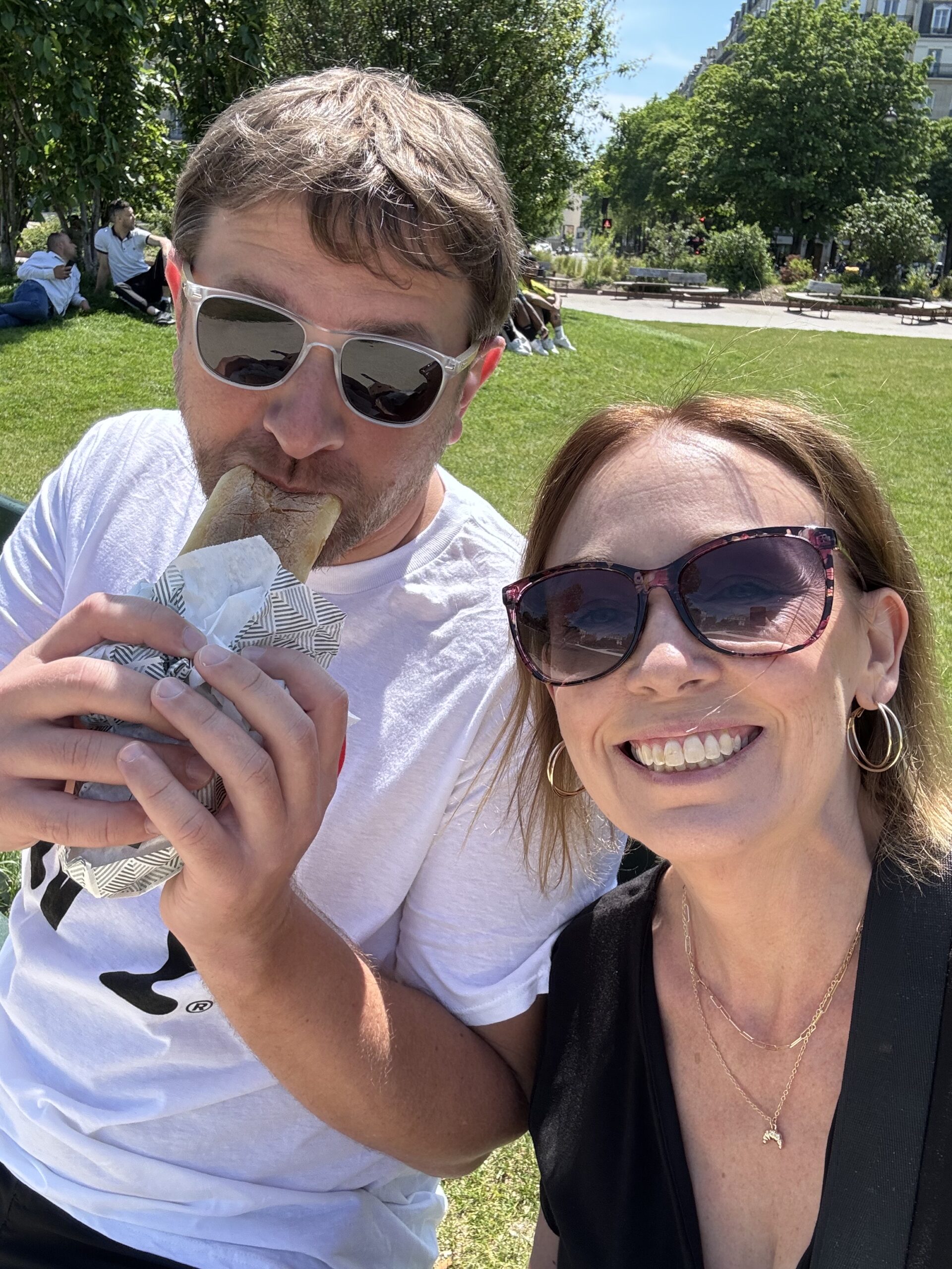 Chad and Karly eating a sandwich in a Paris park.