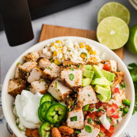 A chicken burrito bowl in front of an air fryer.