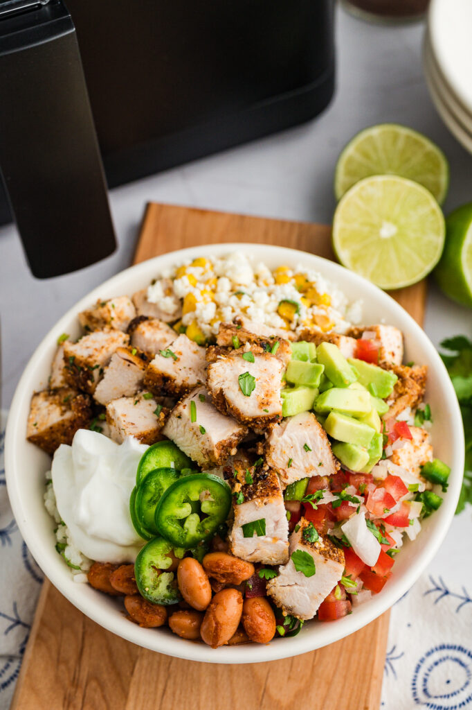 A chicken burrito bowl in front of an air fryer.