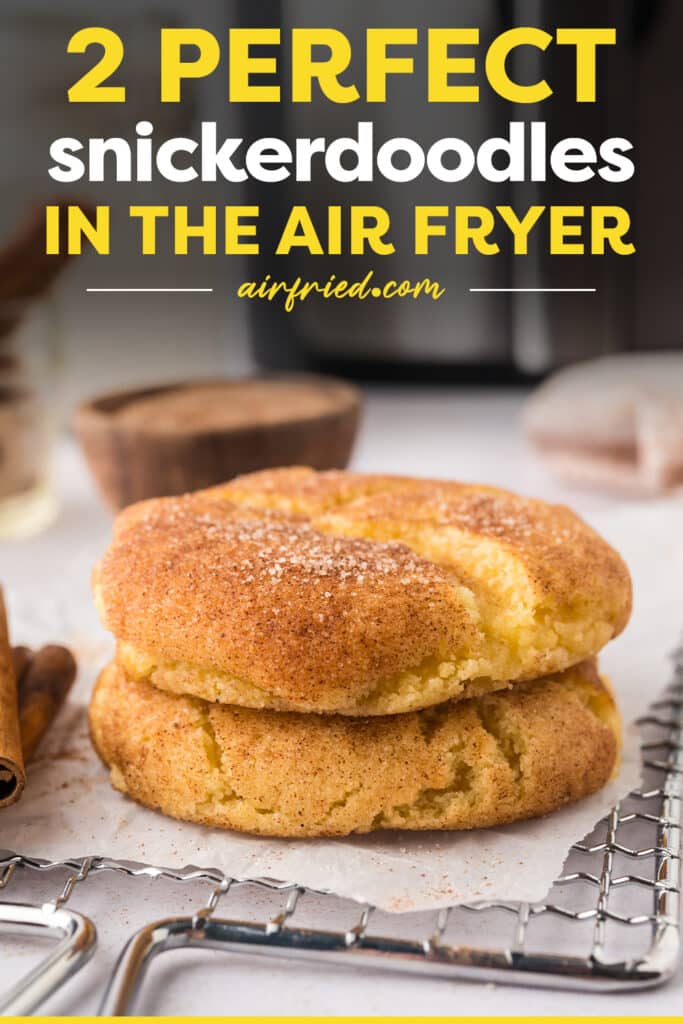 A close-up of two snickerdoodle cookie halves stacked on top of each other, resting on a cooling rack.