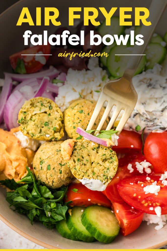 Falafel on a fork surrounded by vegetables.