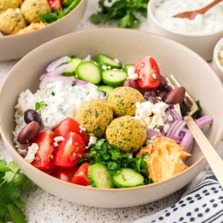 Falafel, rice, and fresh veggies in a bowl.