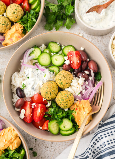 Bowl full of rice, falafel, and fresh veggies.