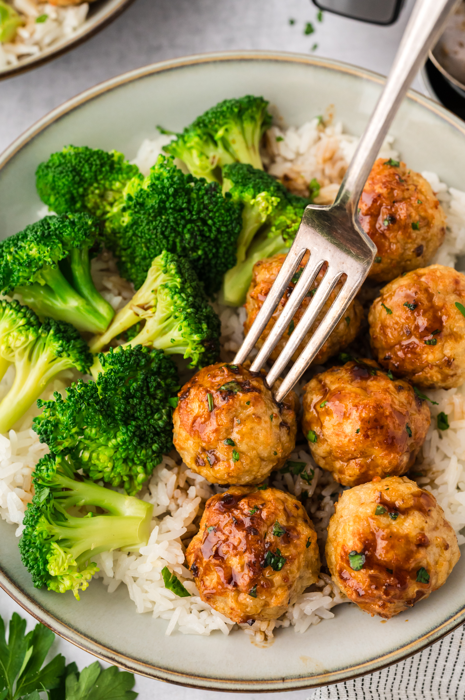 A plate full of chicken meatballs with broccoli.