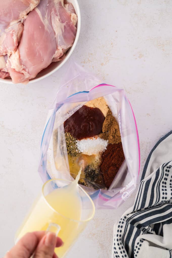 Chipotle seasoning ingredients being poured into a Ziploc bag.