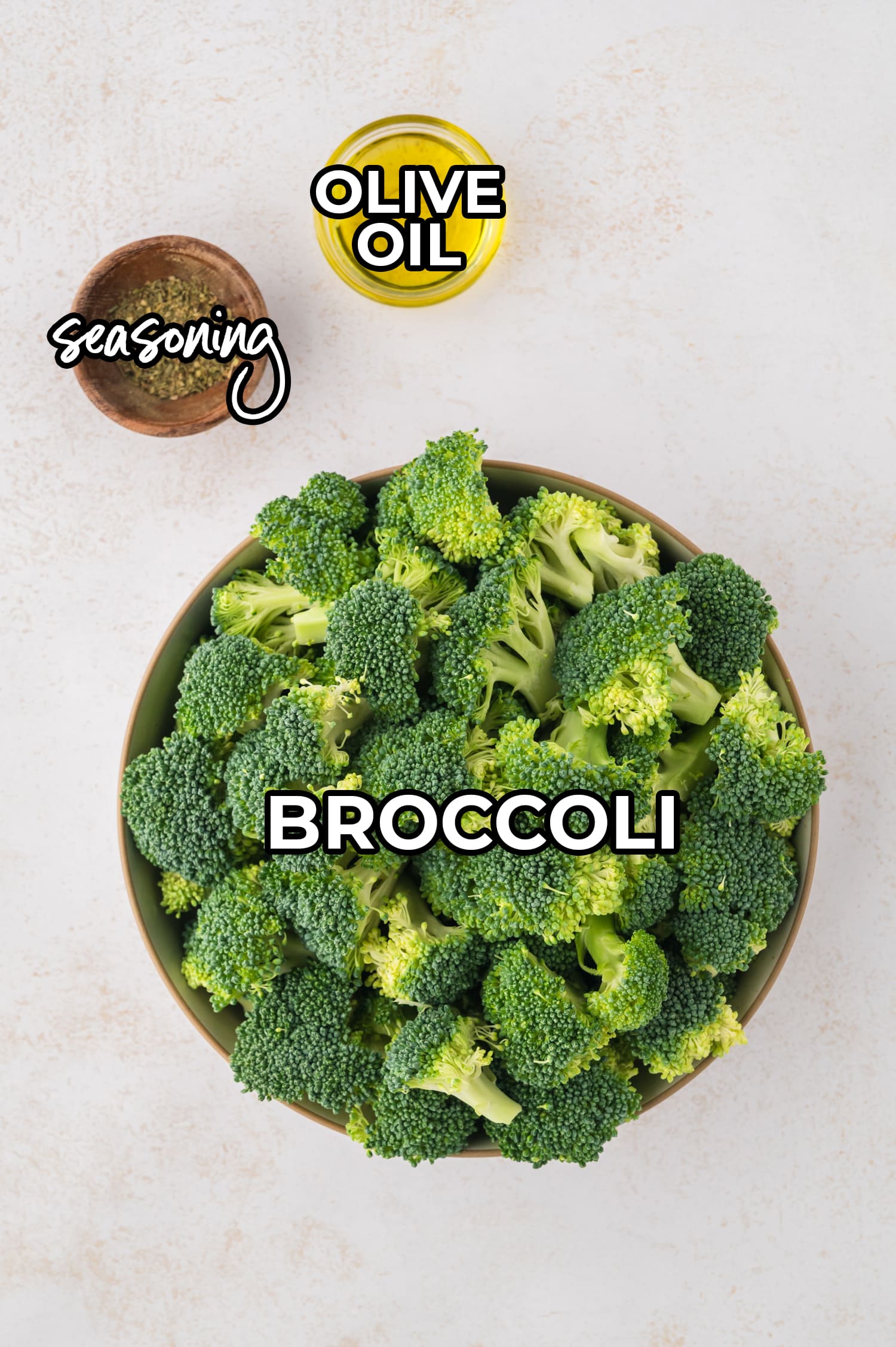 Overhead view of broccoli olive oil and seasoning with text labels.