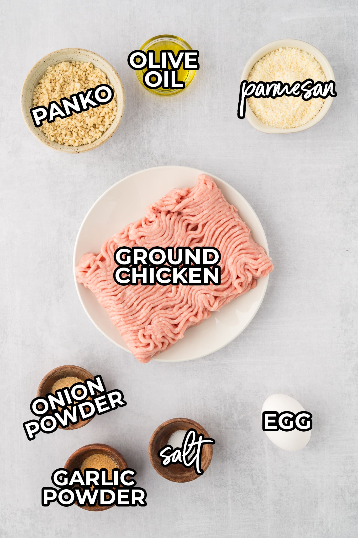 A picture of all of the ingredients needed for chicken meatballs with text over the ingredients.