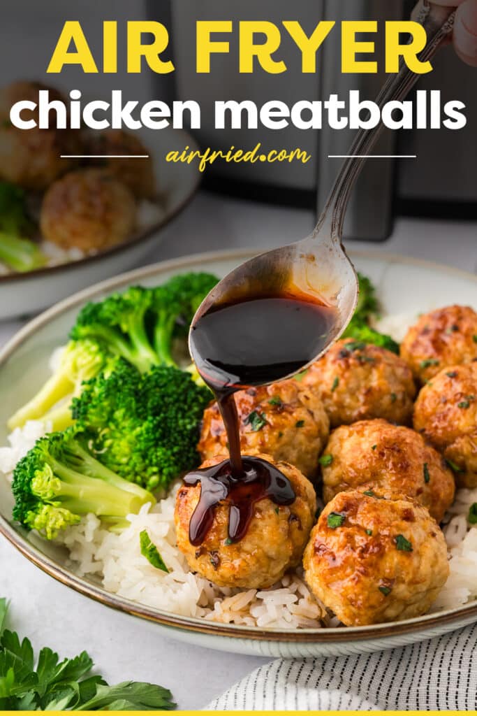 A spoon drizzling sauce over a chicken meatball.