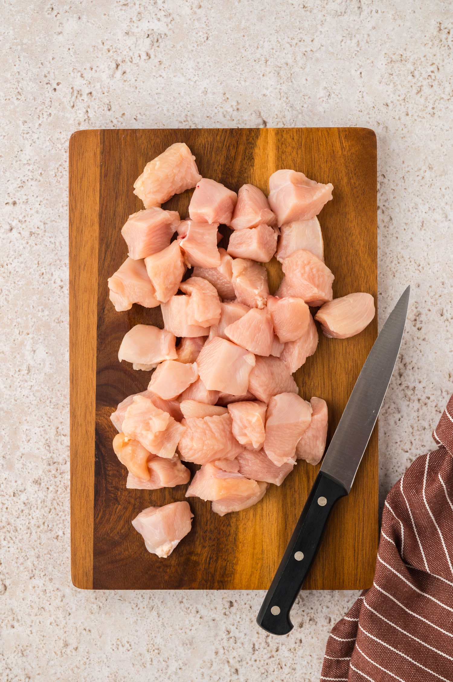 Chicken breast cut on a wooden cutting board.
