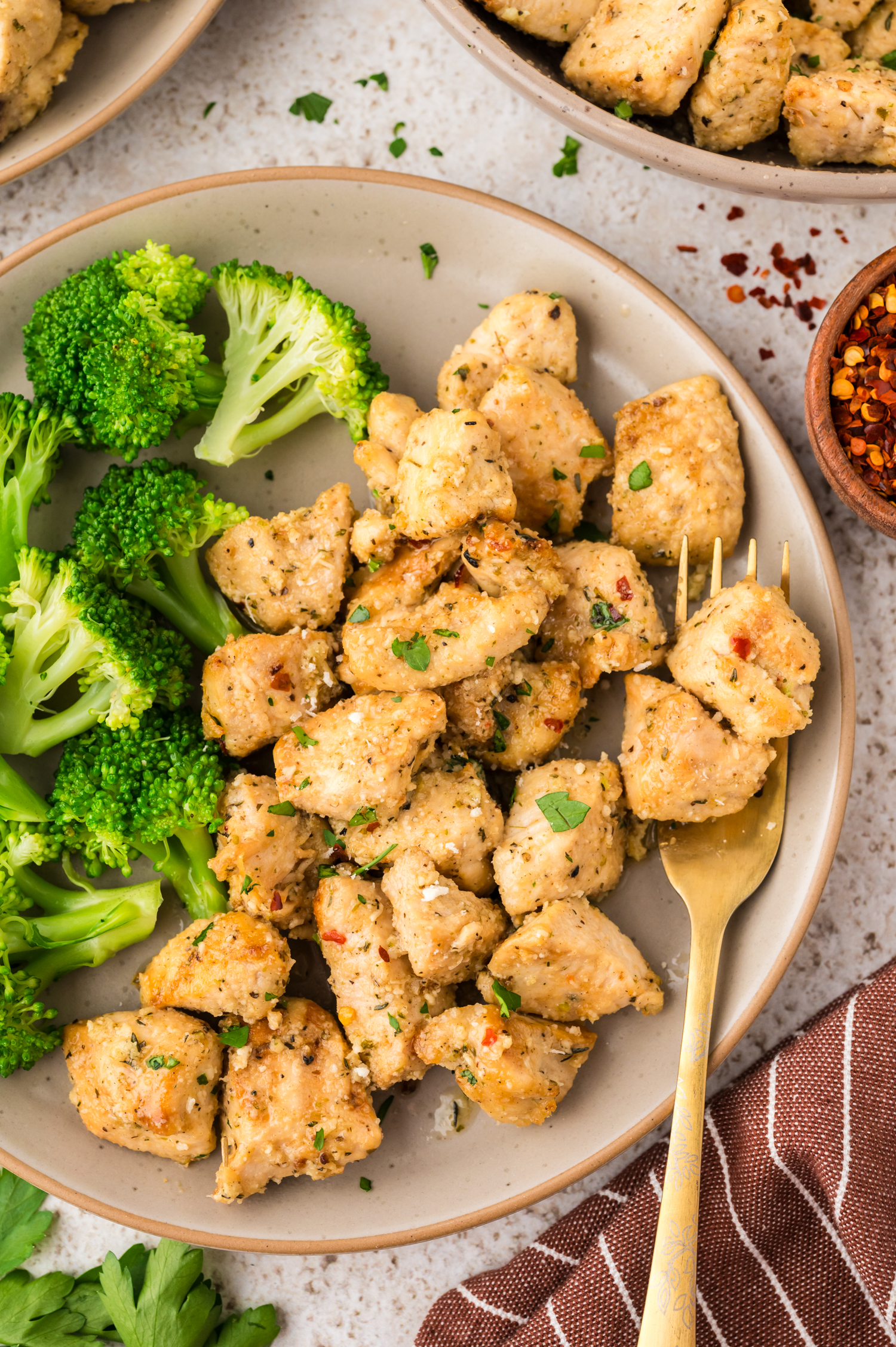 A plate of broccoli and chicken bites.